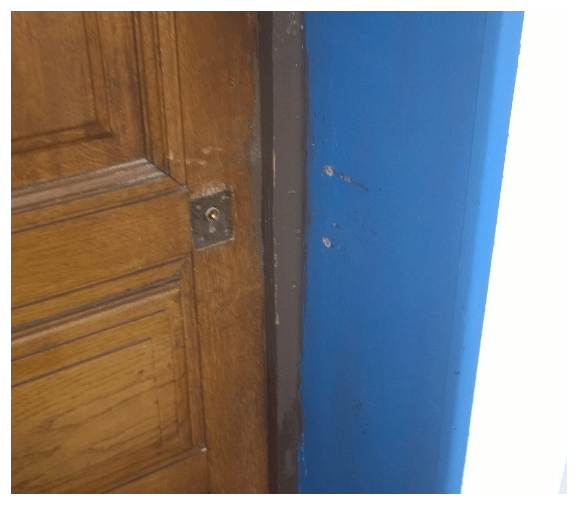 Porte en bois avec un mur bleu. Intervention de serrurerie réalisée par la société ACT Dépannage.
